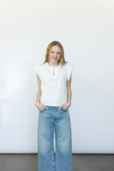 Sleeveless white blouse with ruffles