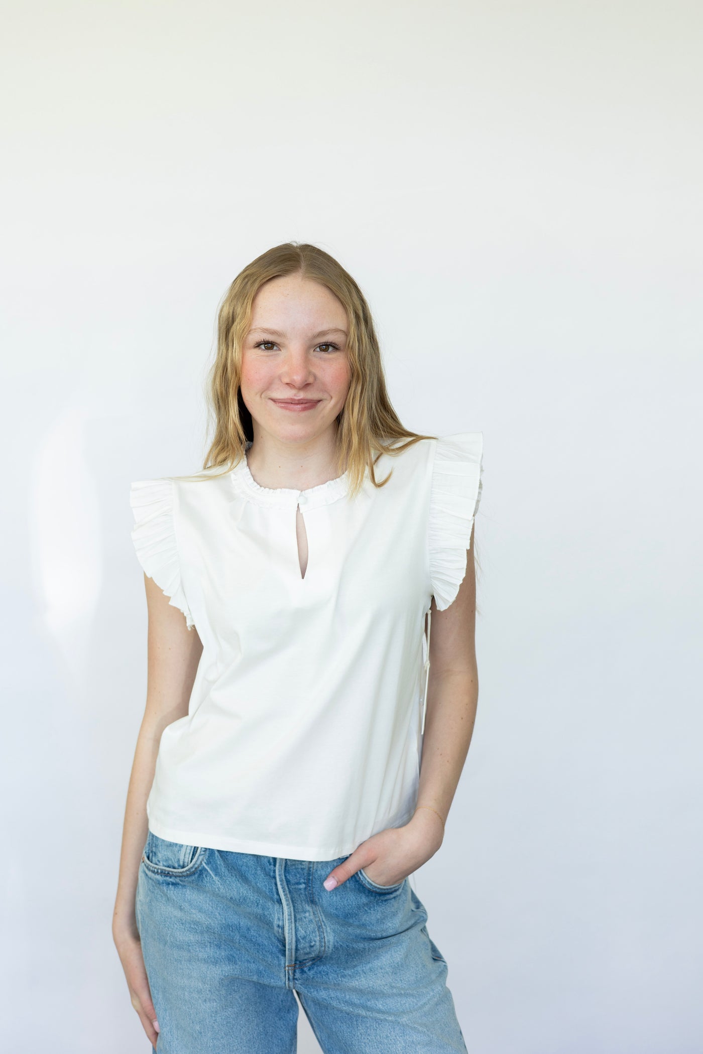 Sleeveless white blouse with ruffles