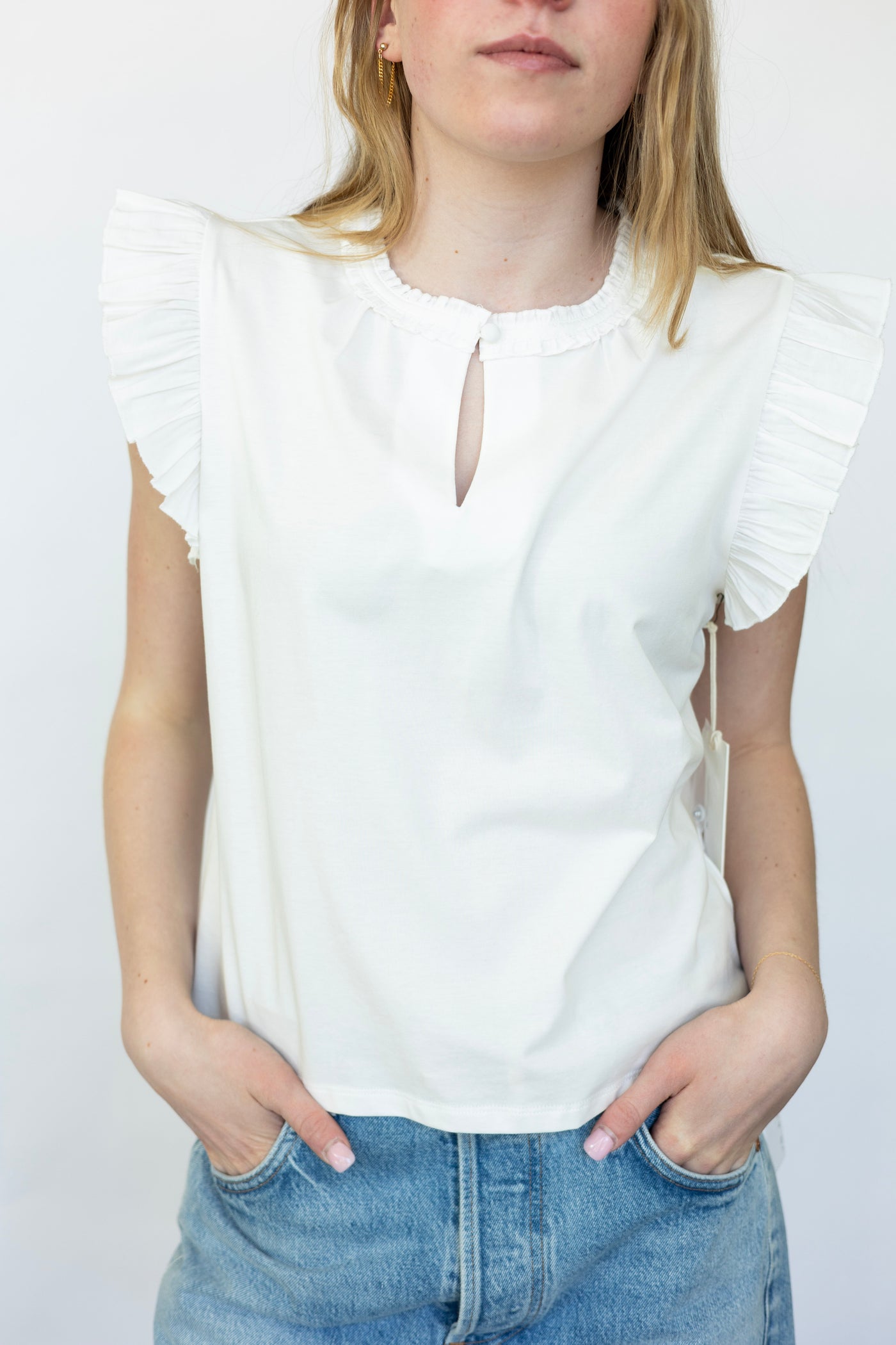 Sleeveless white blouse with ruffles