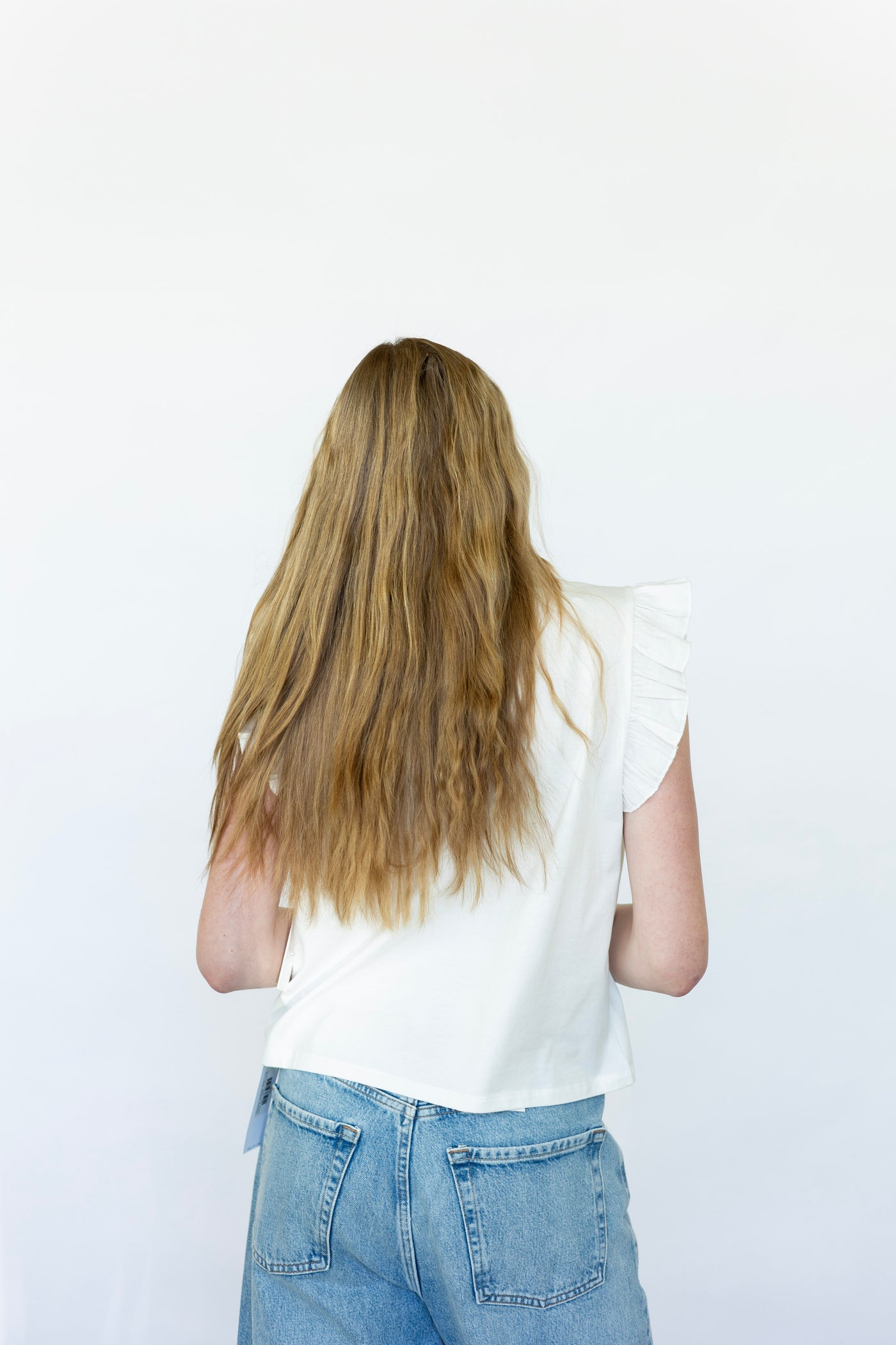 Sleeveless white blouse with ruffles