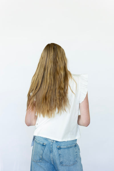 Sleeveless white blouse with ruffles